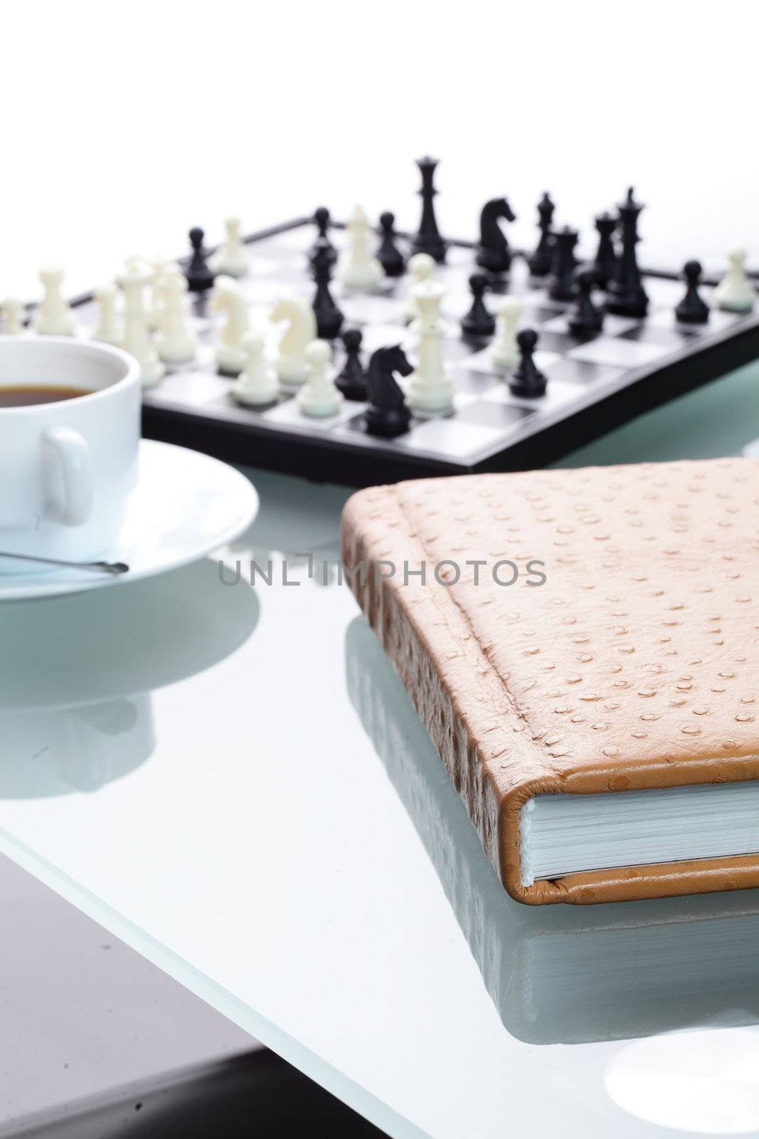 orange leather book on bright background and chess