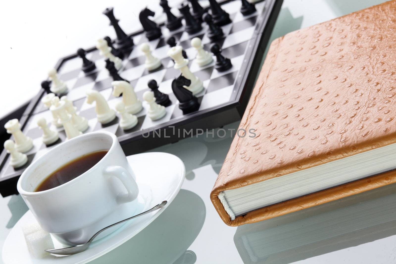 orange leather book on bright background and chess