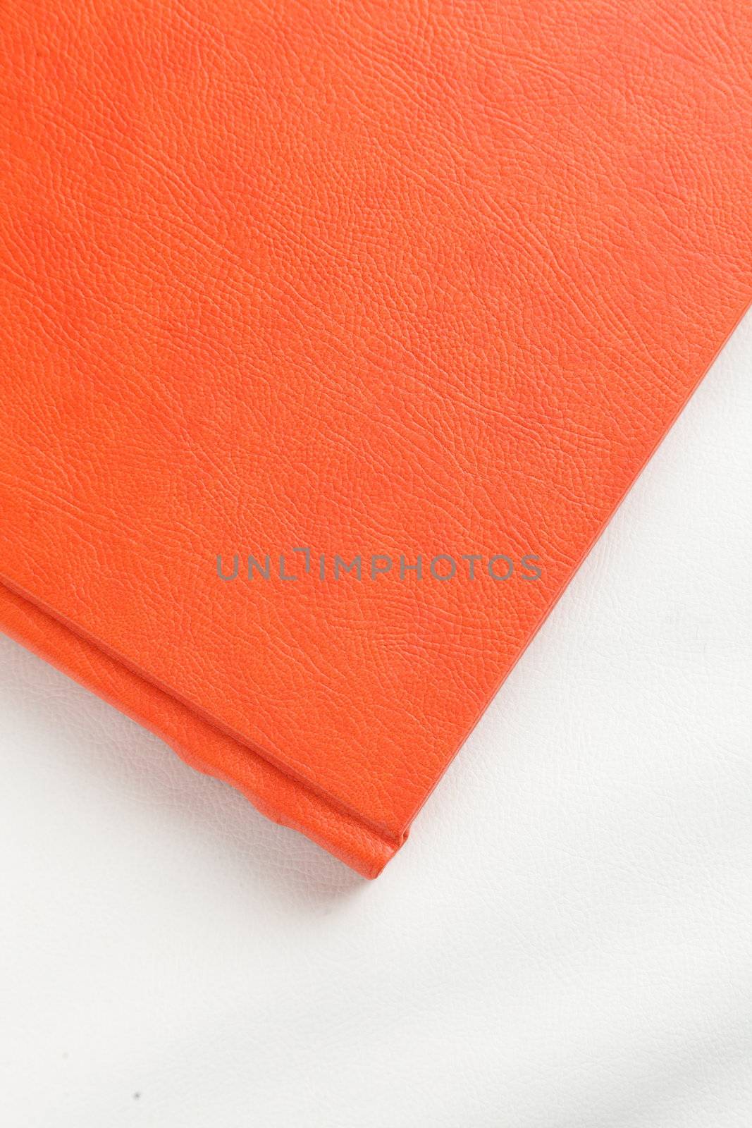 orange leather book on bright background