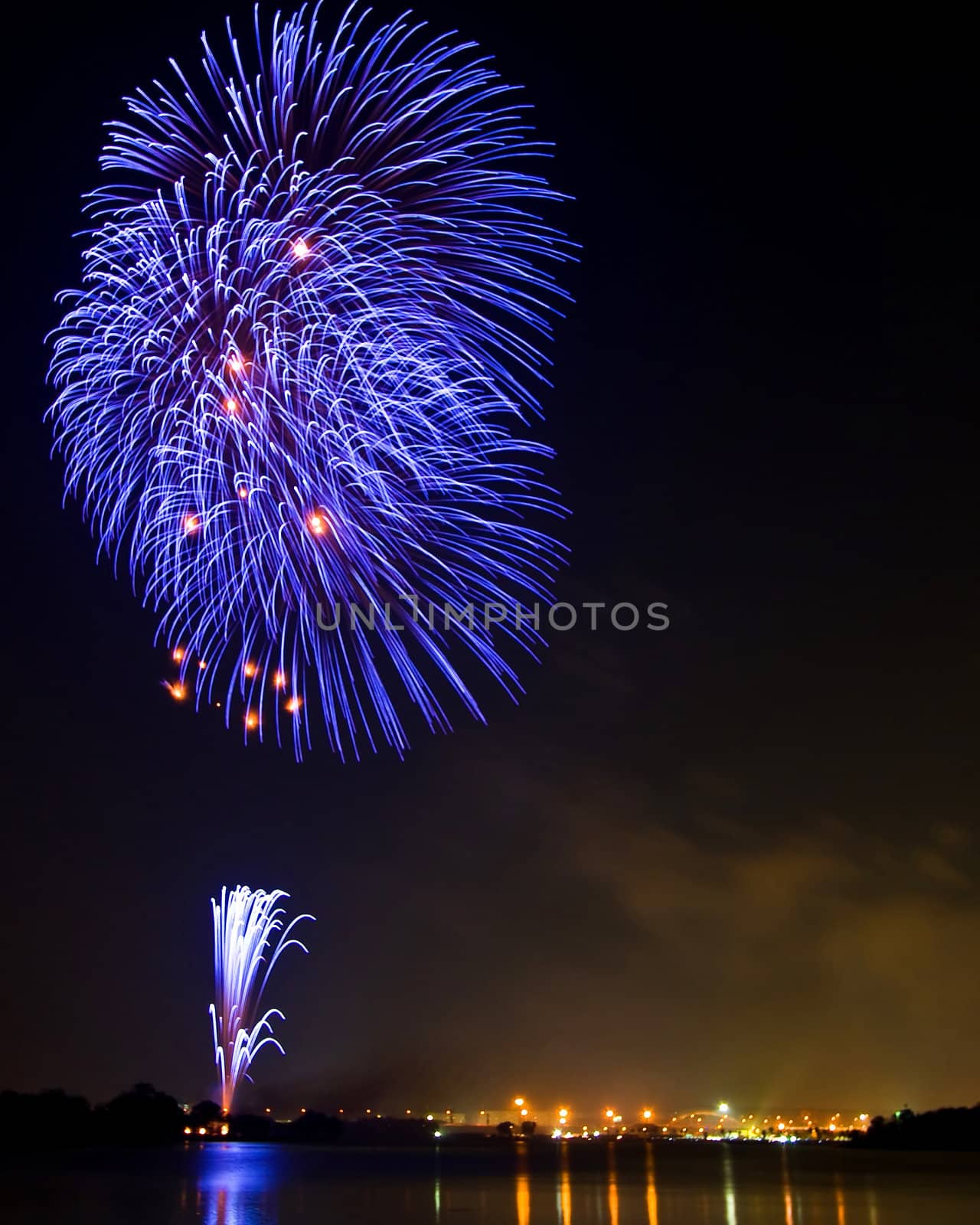 Tree Blue Fireworks at lake on King Birthday Festival and Holiday in Thailand.