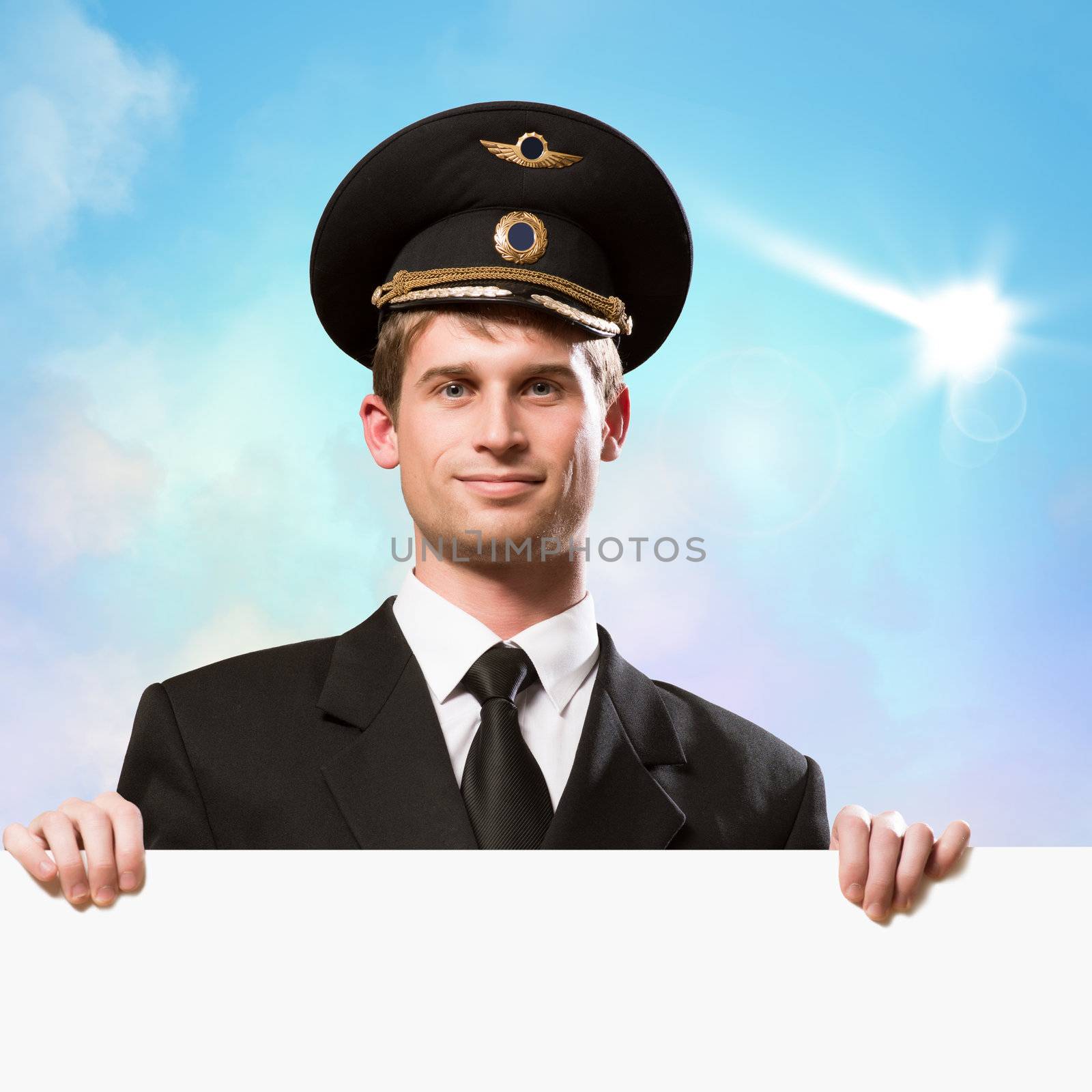 pilot in the form of holding an empty billboard on the background of sky with clouds, place for text