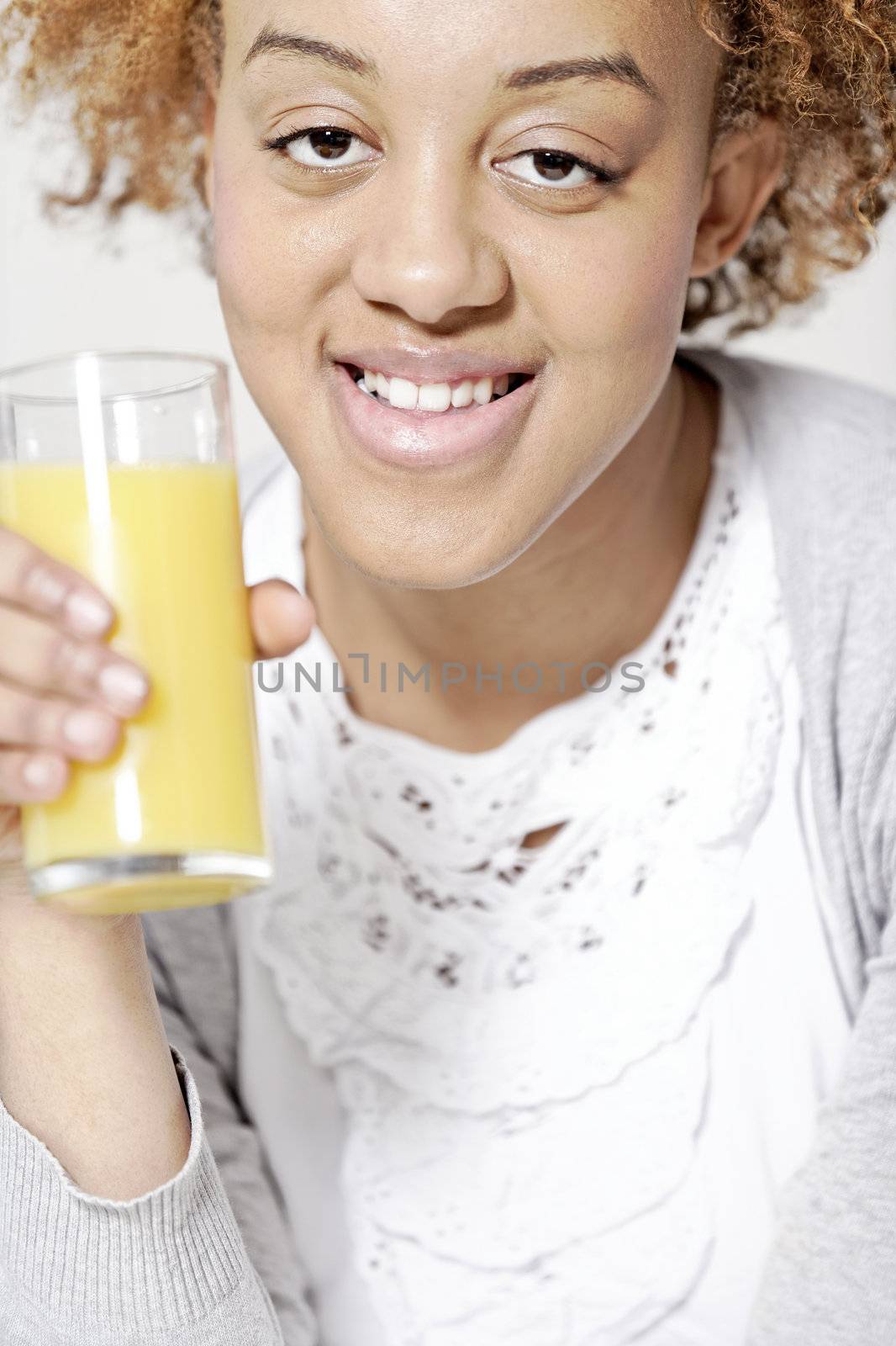 Attractive black woman  relaxing in living room with a glass of juice