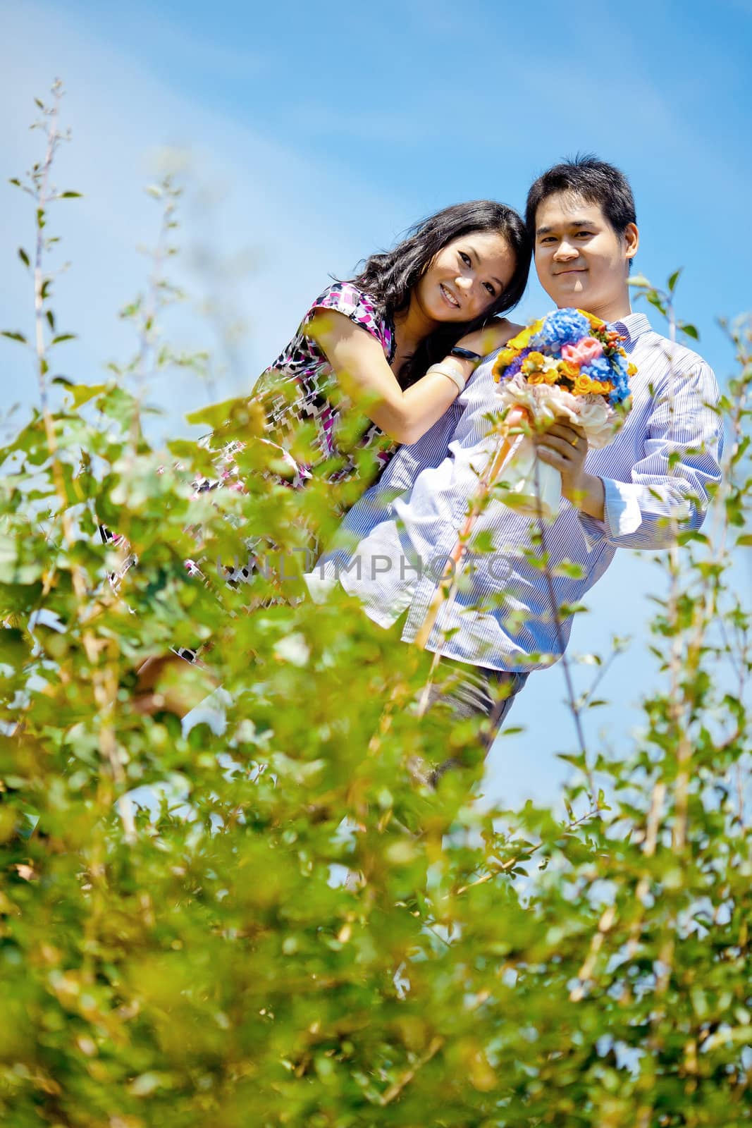 young bride embracing groom with flowers bouquet