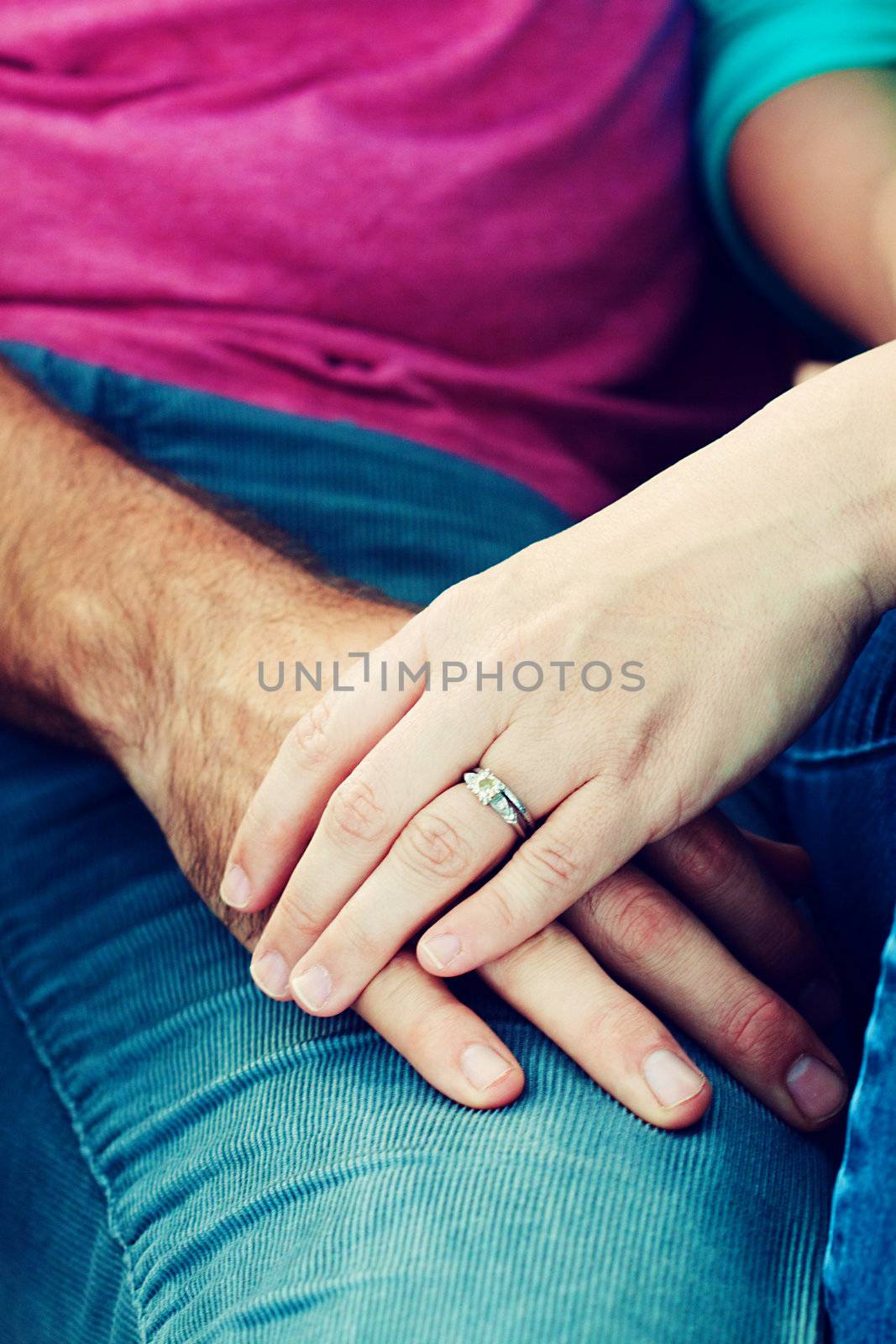 Close up picture of holding hands and engagement ring