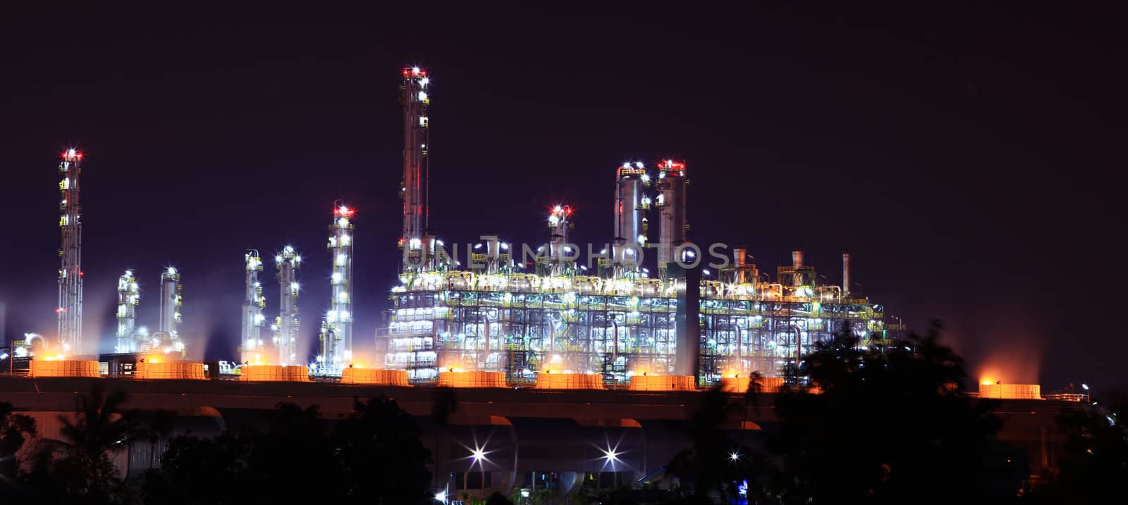 panoramic view of oil refinery factory at night by vichie81