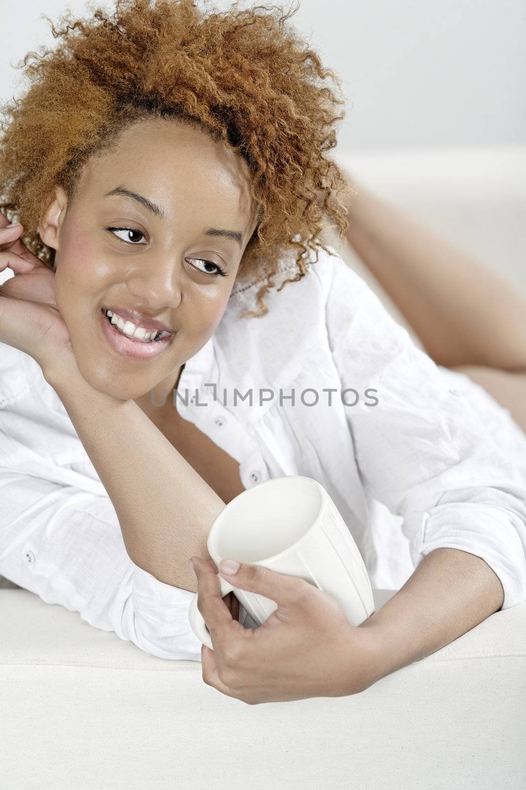 Attractive young woman lying on her sofa at home relaxing