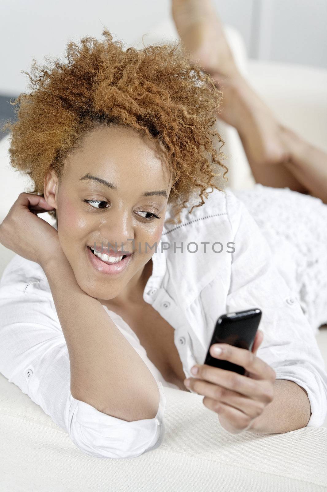 Beautiful young woman texting on her phone to friends