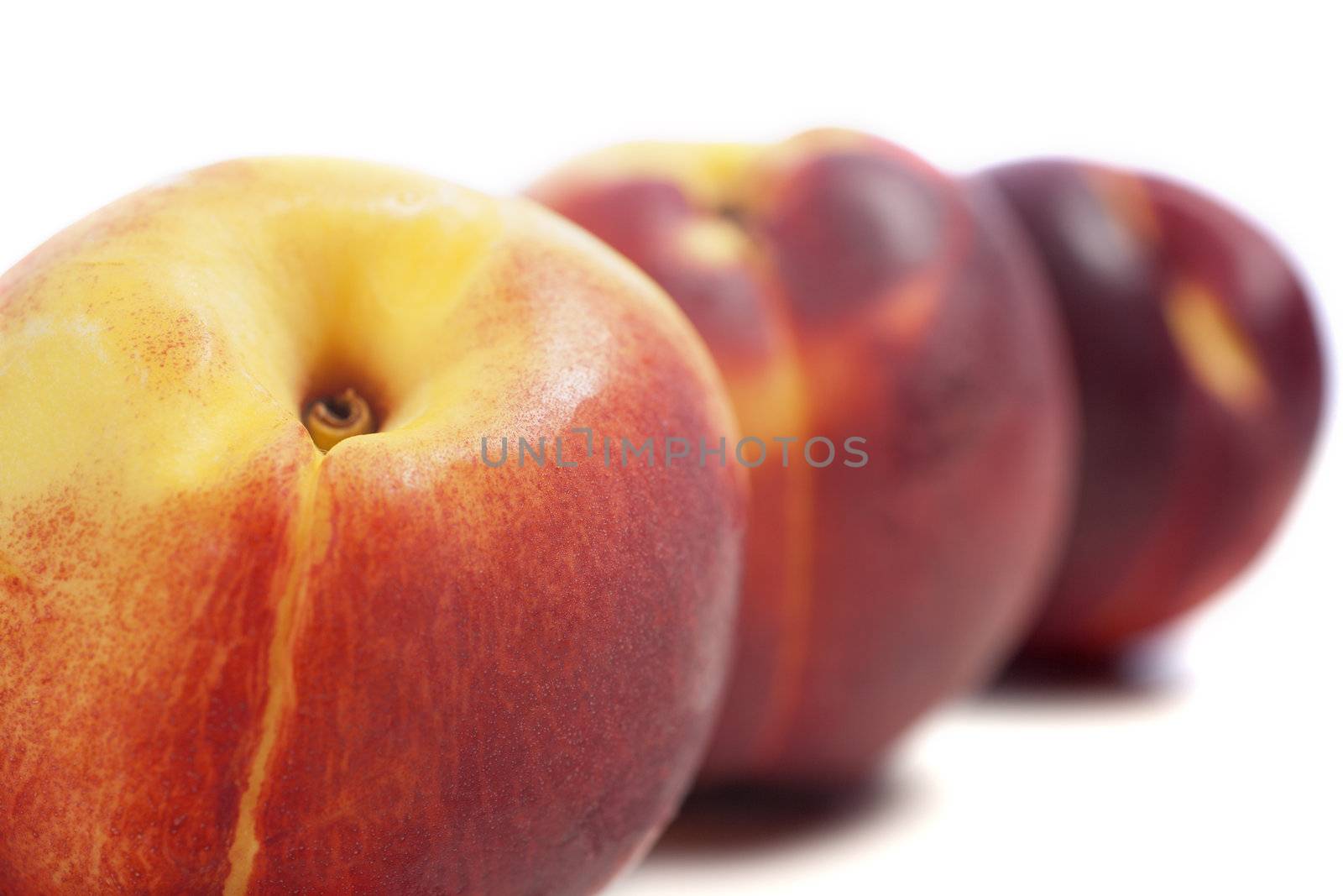 Three fresh nectarines on an isolated background