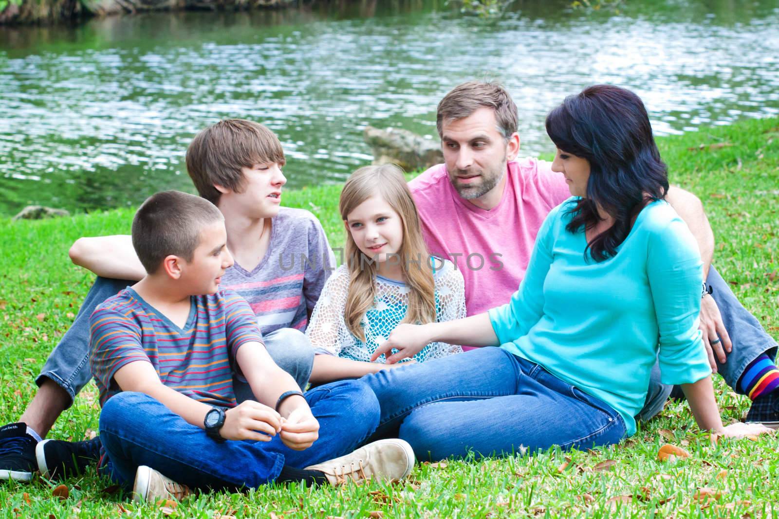 Portrait of a family sitting on a grass in the park