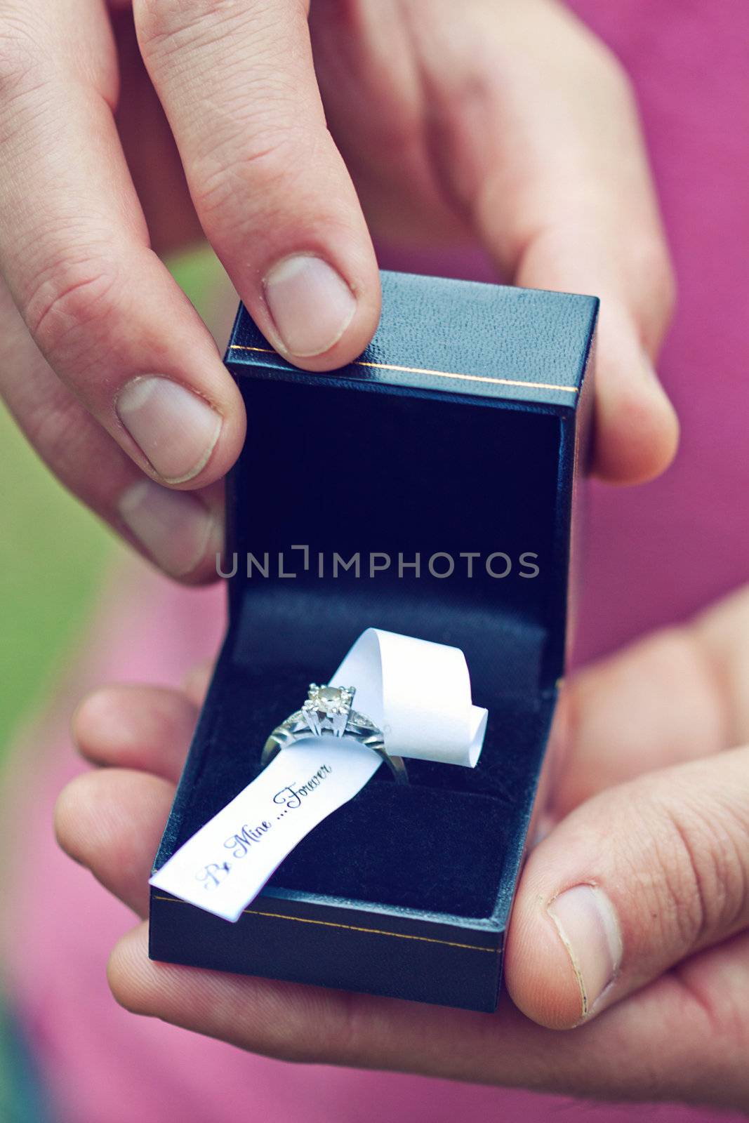 Hands holding a box with engagement ring saying be mine forever 