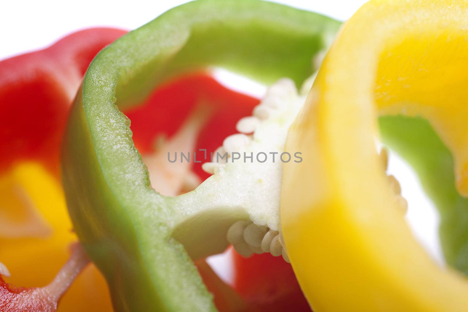 Red Yellow and Green peppers sliced on an isolated white background