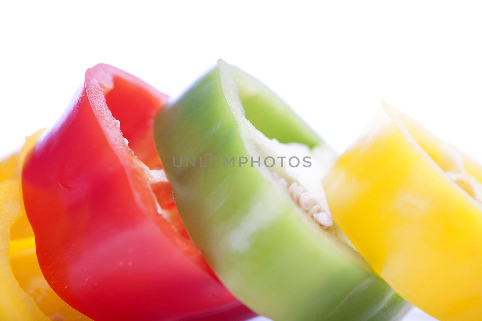Red Yellow and Green peppers sliced on an isolated white background