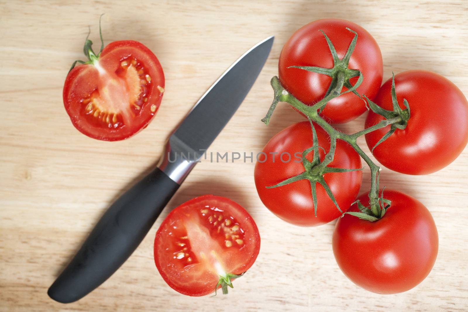 Fresh tomatoes on a chopping board by studiofi