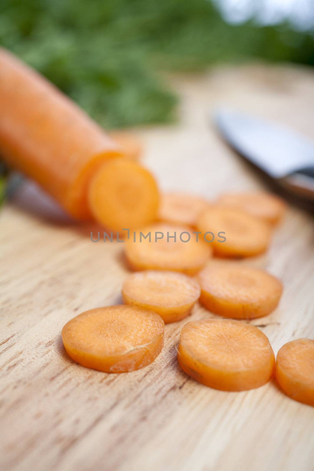 Fresh organic carrots on a wooden chopping board with knife