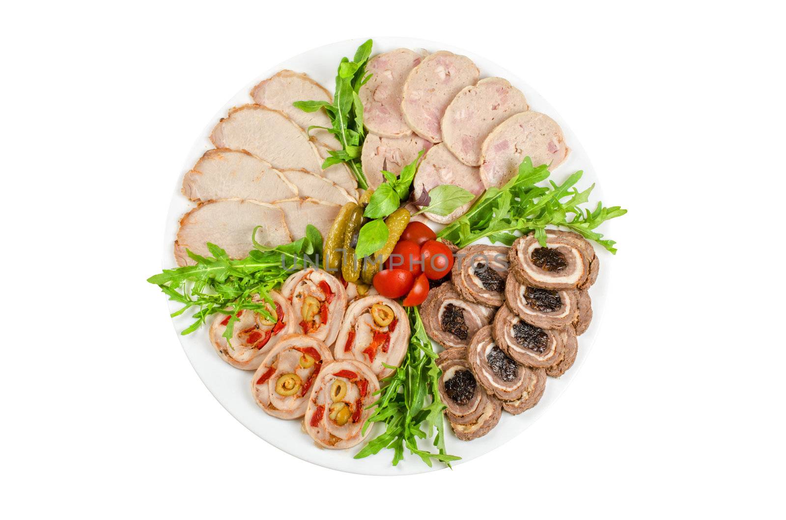 Cutting meat tenderloin with prune, olive, pepper, lettuce, tomatoes, cucumbers and ruccola at plate on a white