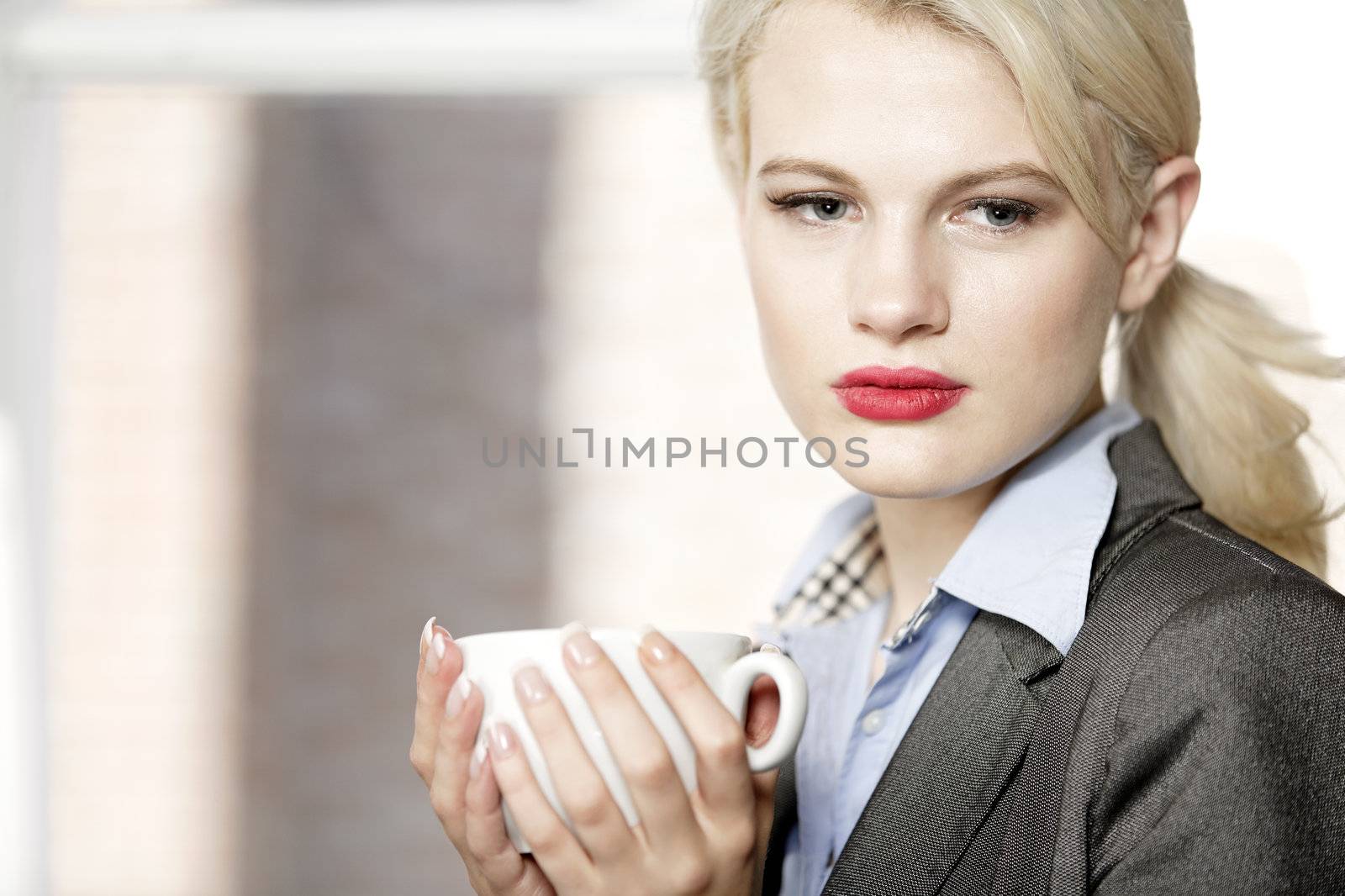 professional business woman drinking a mug of coffee at work.