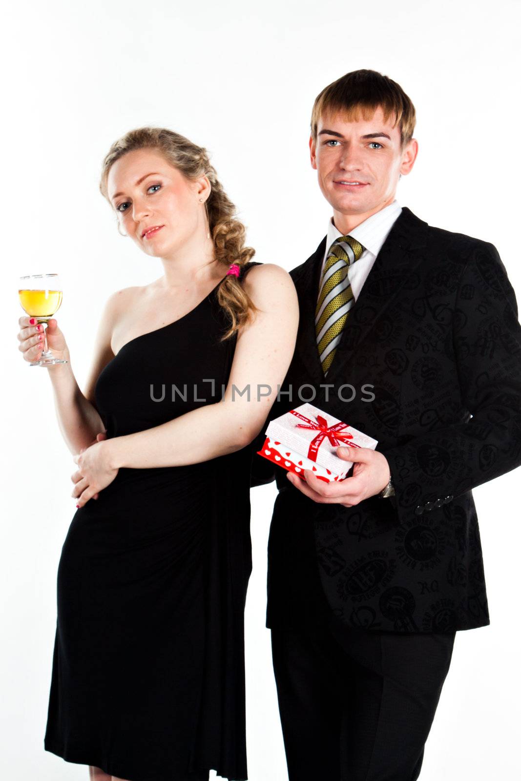 Portrait of a beautiful young couple with glasses of wine and a gift box with a red bow