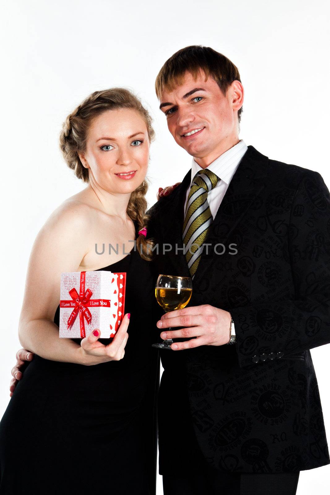 Portrait of a beautiful young couple with glasses of wine and a gift box with a red bow