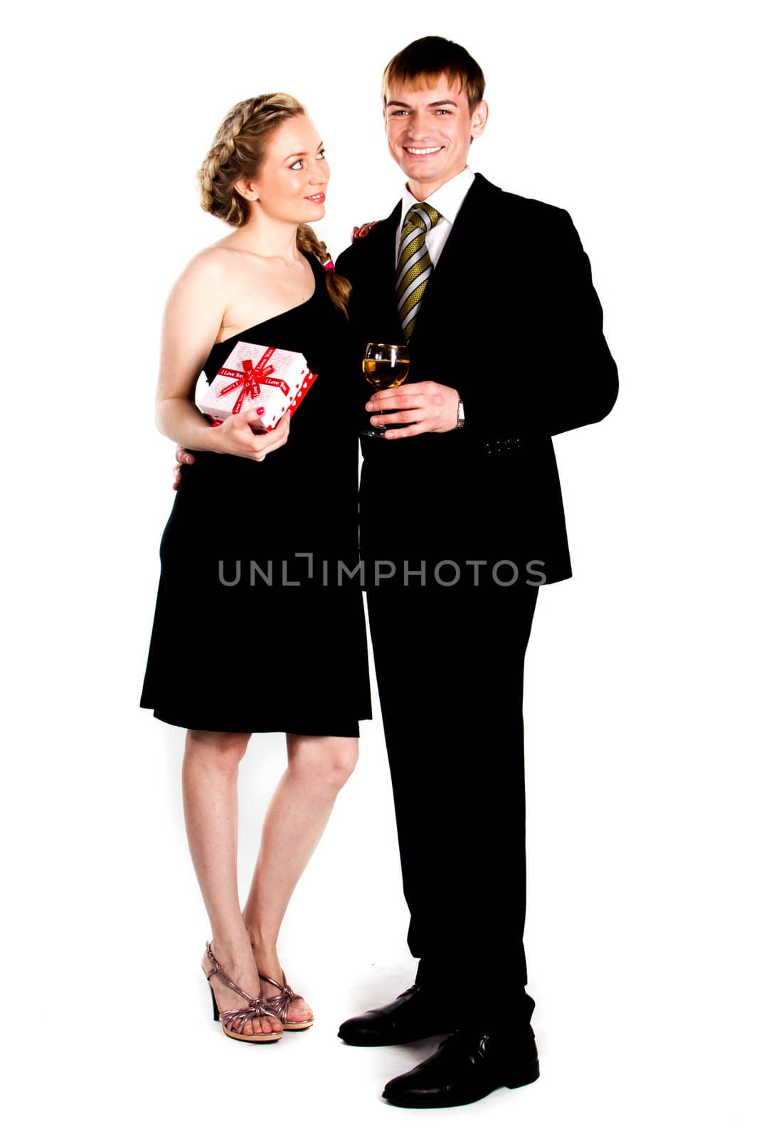 Portrait of a beautiful young couple with glasses of wine and a gift box with a red bow