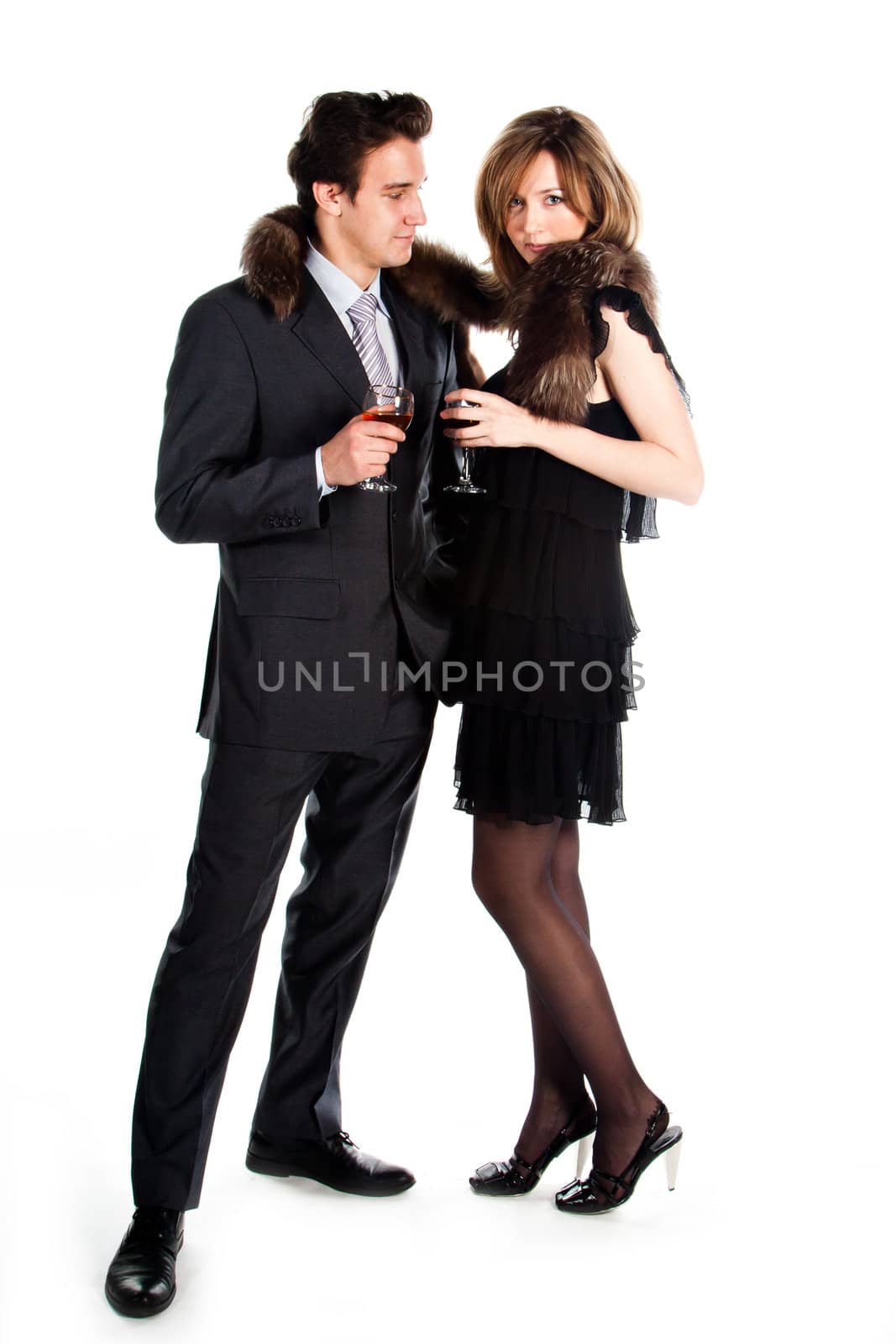Portrait of a beautiful young couple with glasses of wine and a gift box with a red bow