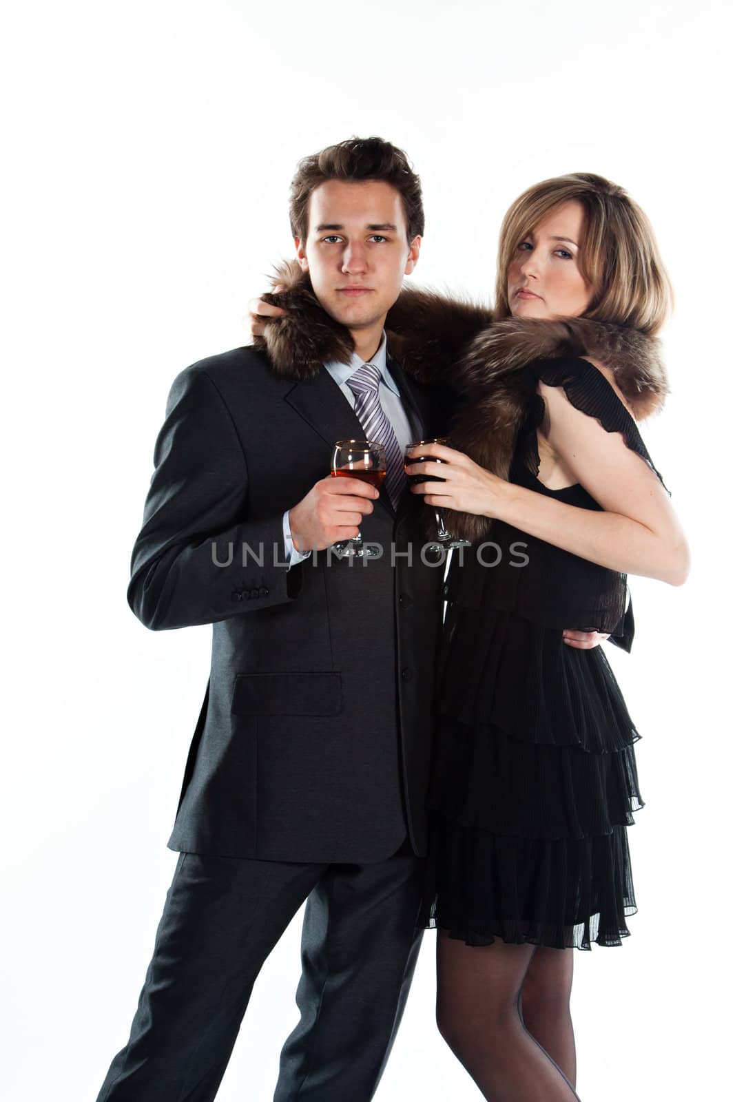 Portrait of a beautiful young couple with glasses of wine and a gift box with a red bow