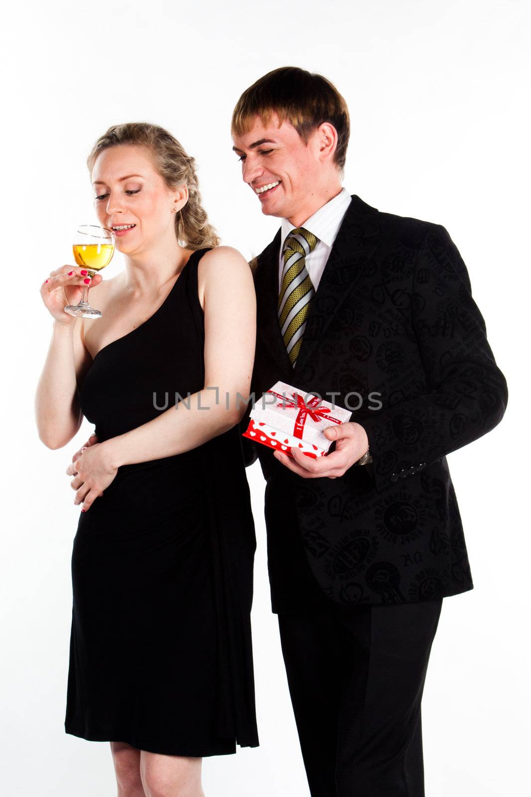 Portrait of a beautiful young couple with glasses of wine and a gift box with a red bow