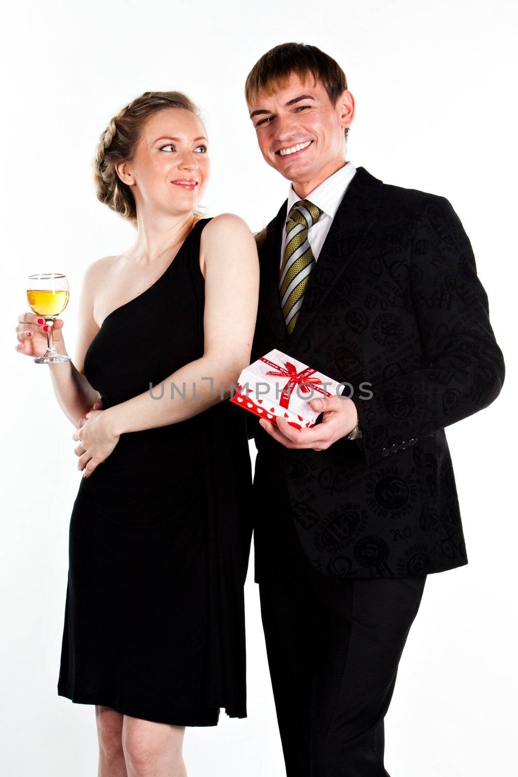 Portrait of a beautiful young couple with glasses of wine and a gift box with a red bow