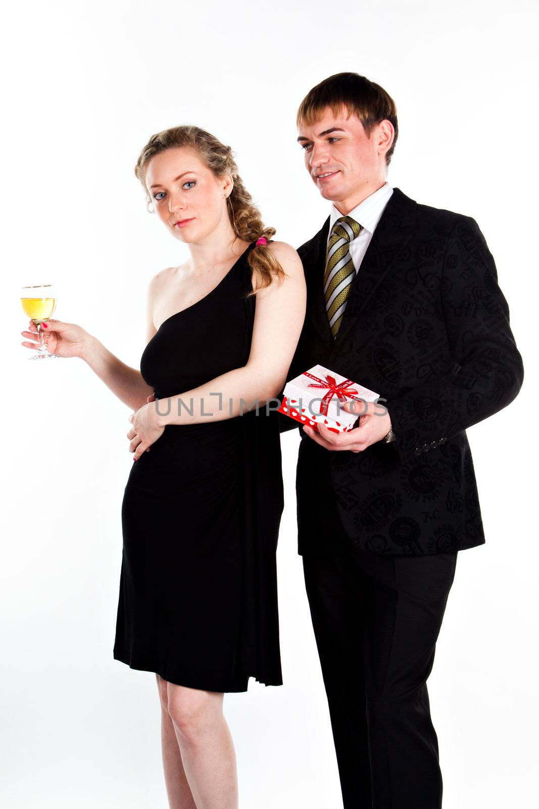 Portrait of a beautiful young couple with glasses of wine and a gift box with a red bow