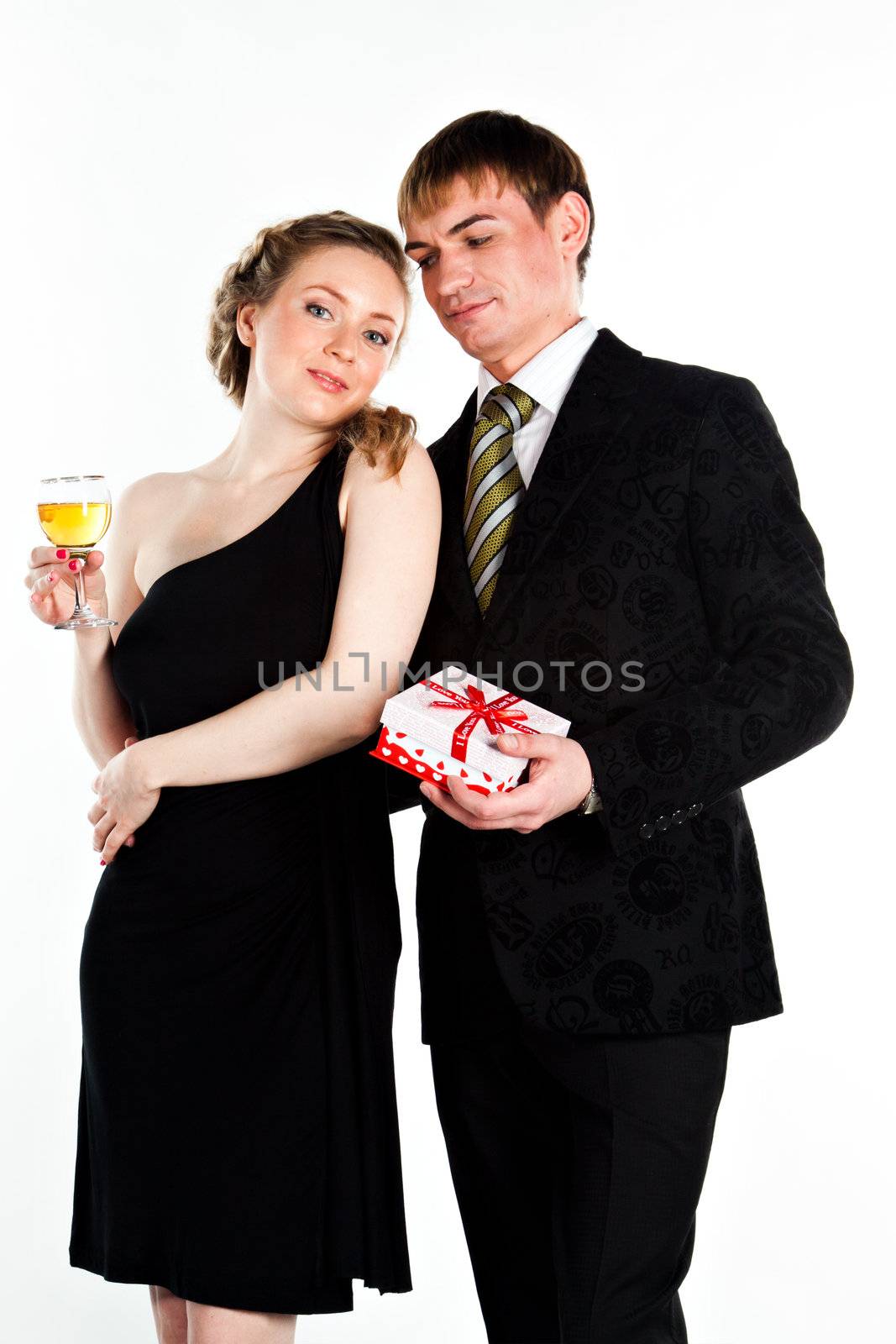 Portrait of a beautiful young couple with glasses of wine and a gift box with a red bow