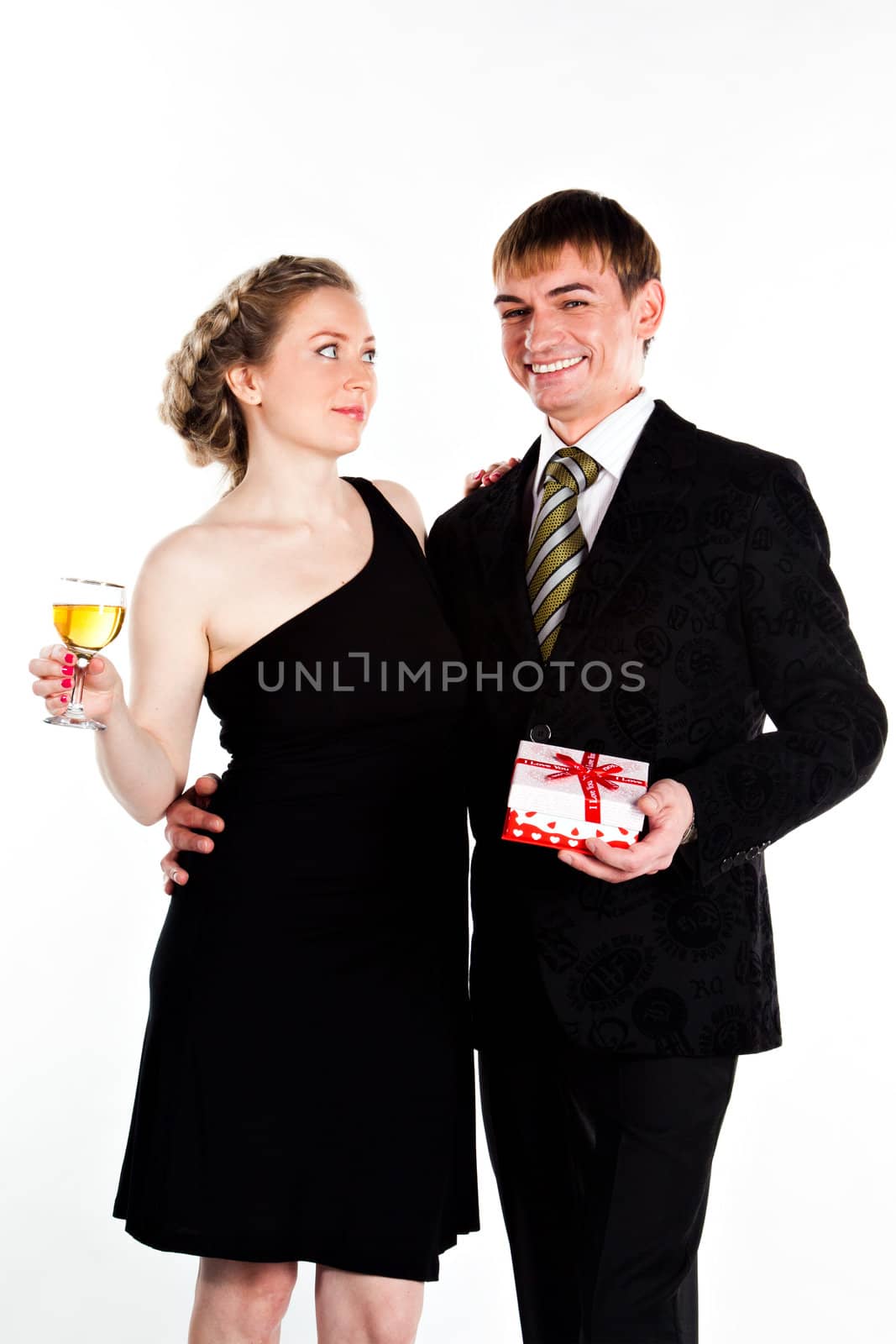 Portrait of a beautiful young couple with glasses of wine and a gift box with a red bow