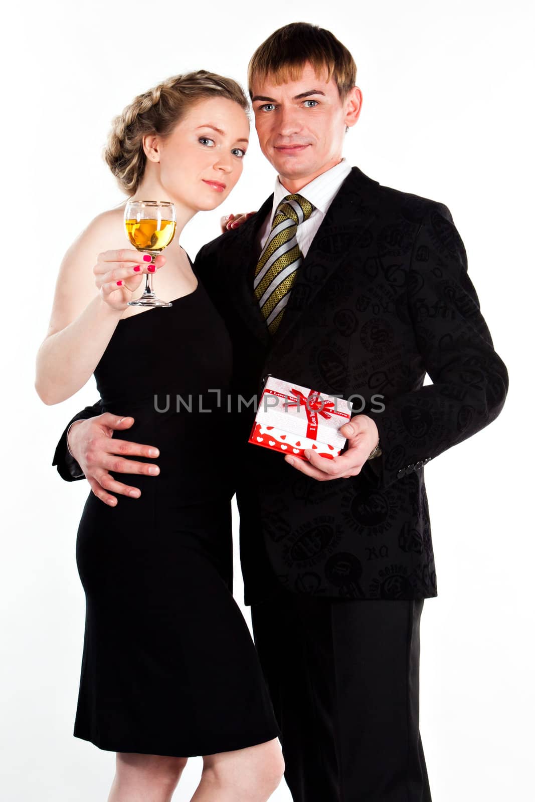 Portrait of a beautiful young couple with glasses of wine and a gift box with a red bow