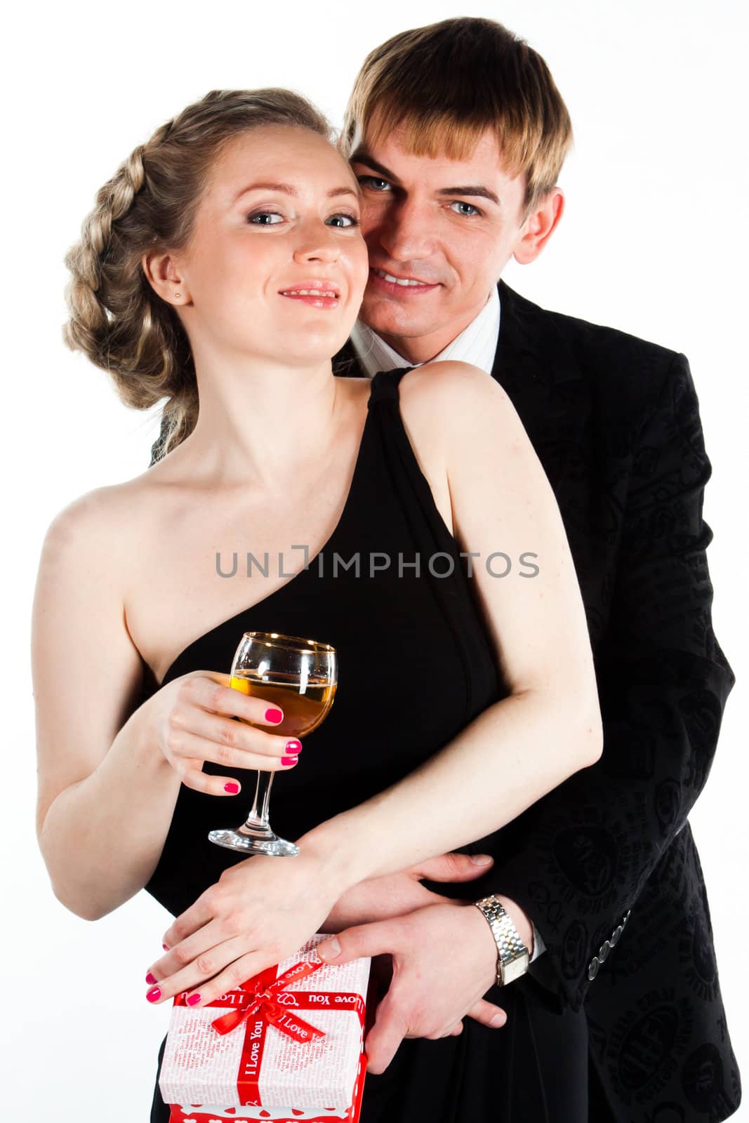 Portrait of a beautiful young couple with glasses of wine and a gift box with a red bow