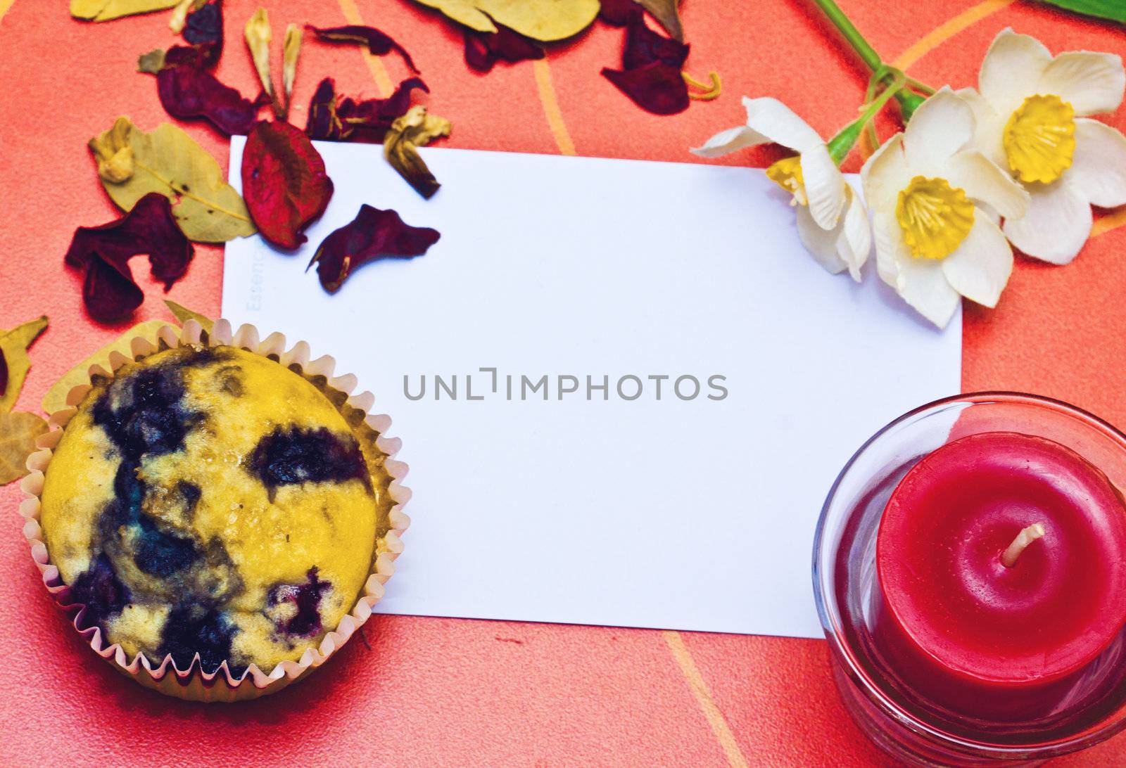 Cupcake with a note and a flower on the table 