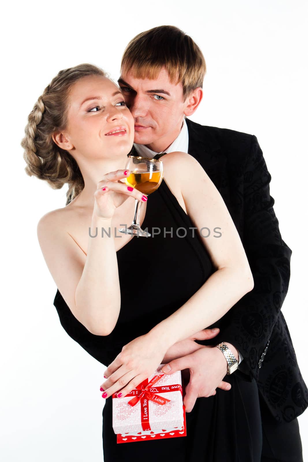 Portrait of a beautiful young couple with glasses of wine and a gift box with a red bow