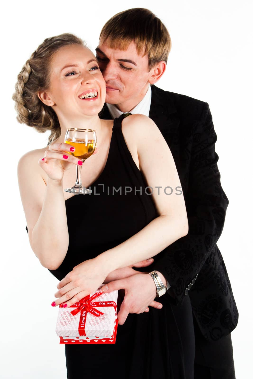 Portrait of a beautiful young couple with glasses of wine and a gift box with a red bow