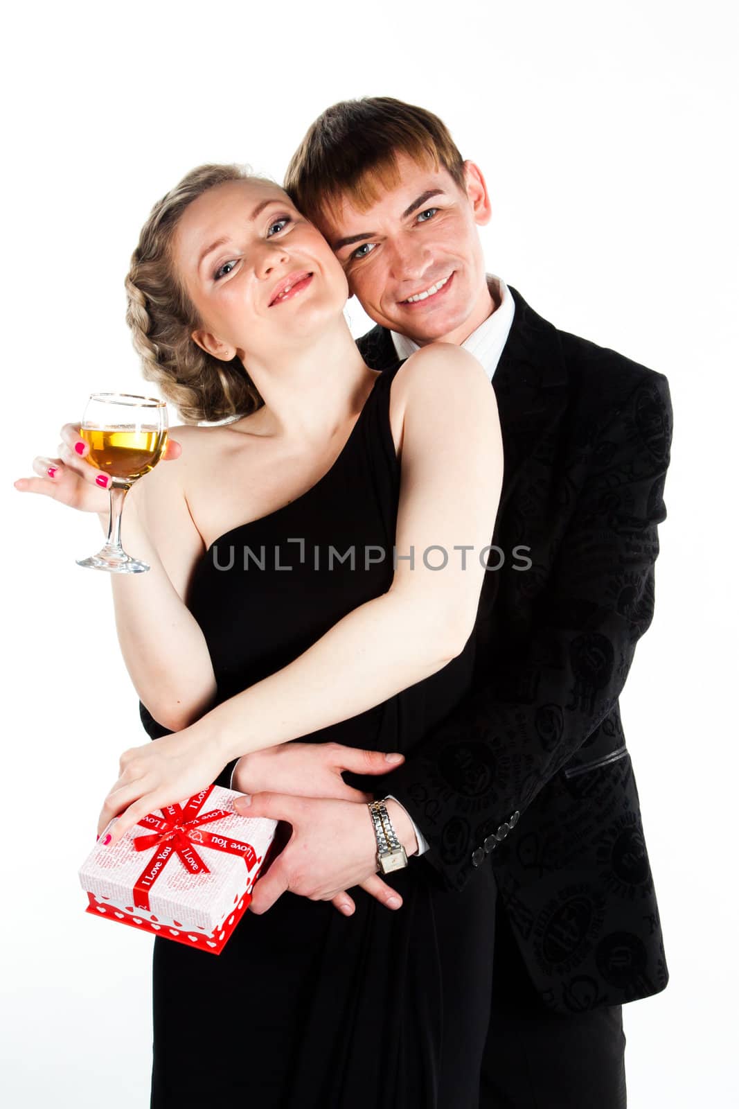 Portrait of a beautiful young couple with glasses of wine and a gift box with a red bow