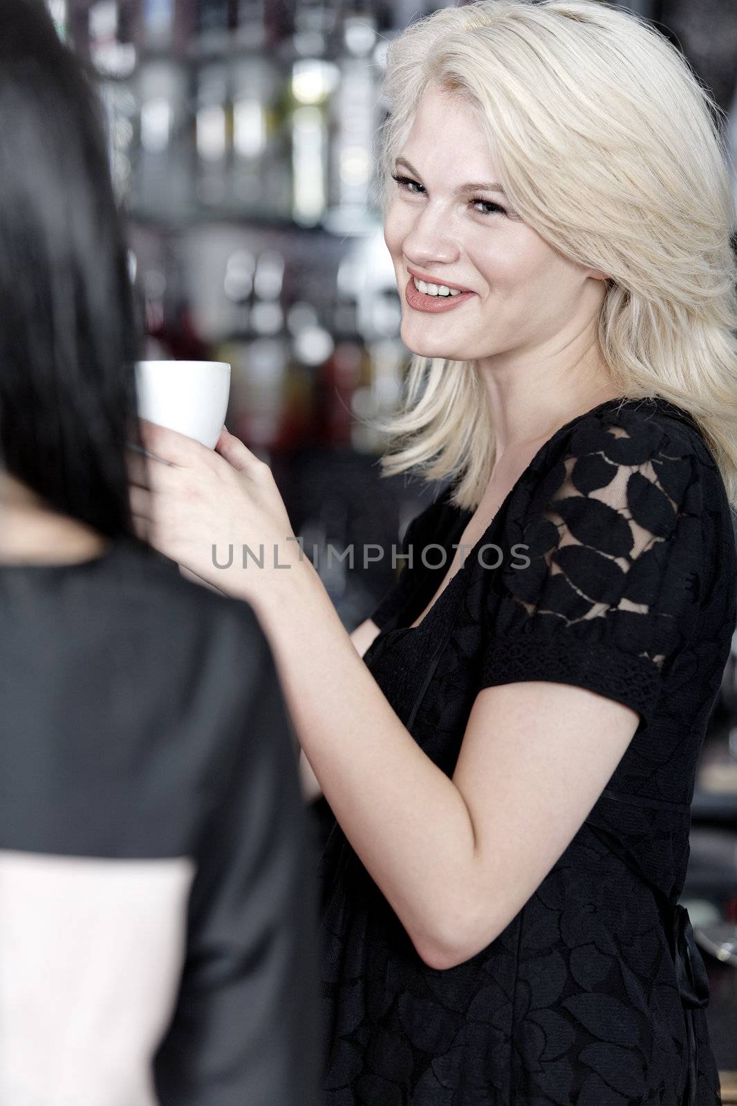 Beautiful young woman talking over coffee at a wine bar.