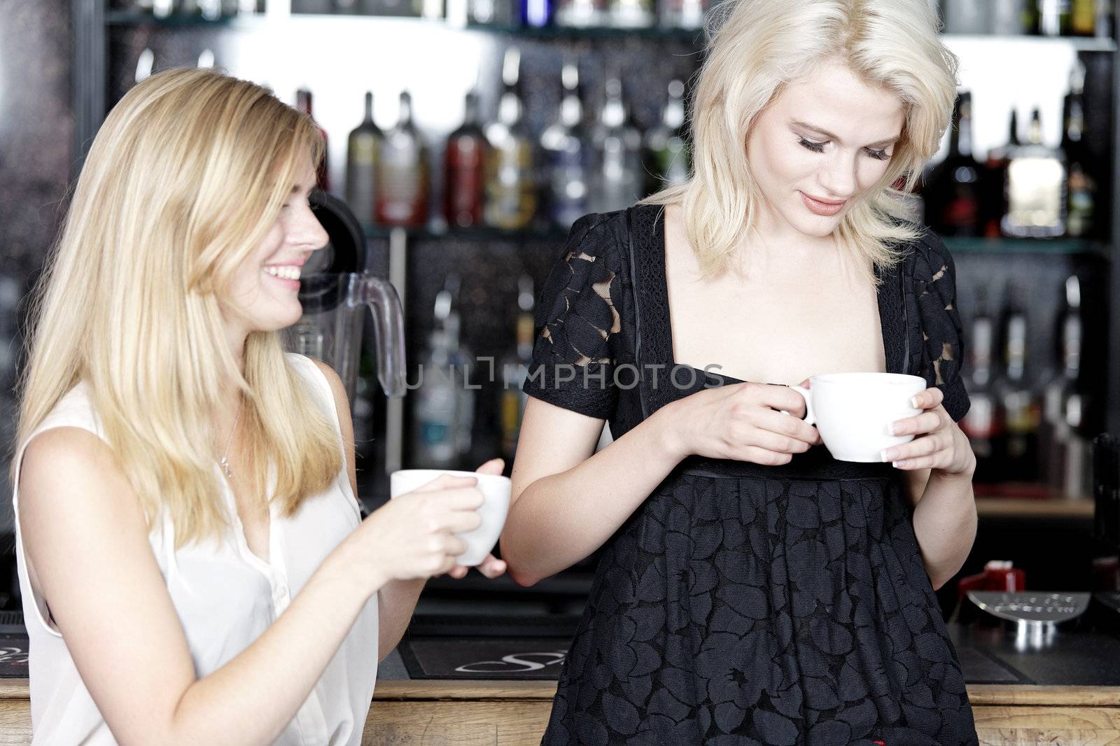 Beautiful young woman talking over coffee at a wine bar.