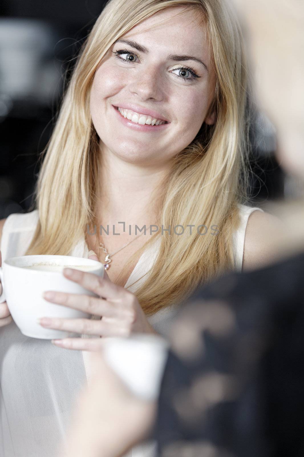 Beautiful young woman talking over coffee at a wine bar.