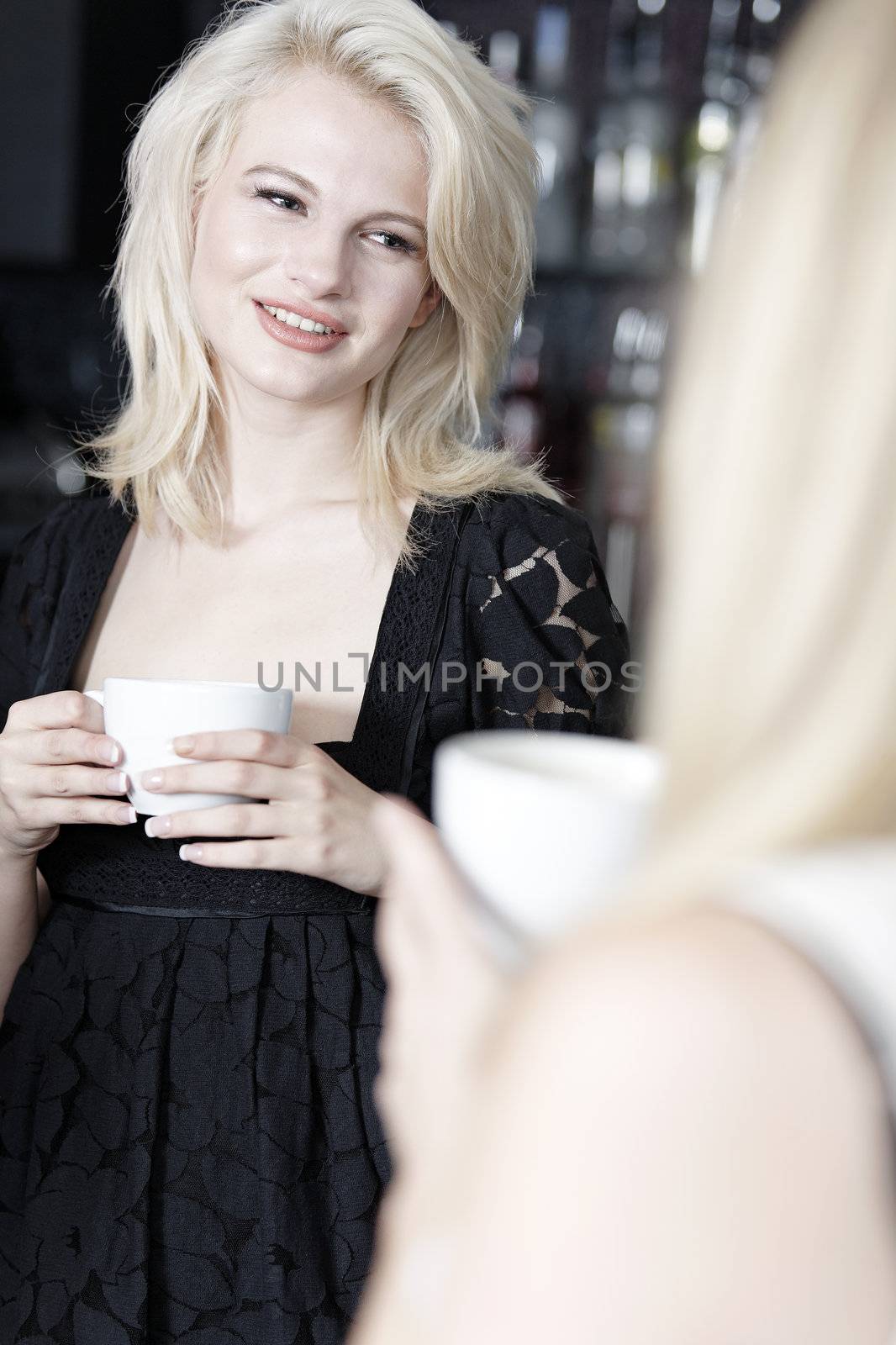 Beautiful young woman talking over coffee at a wine bar.