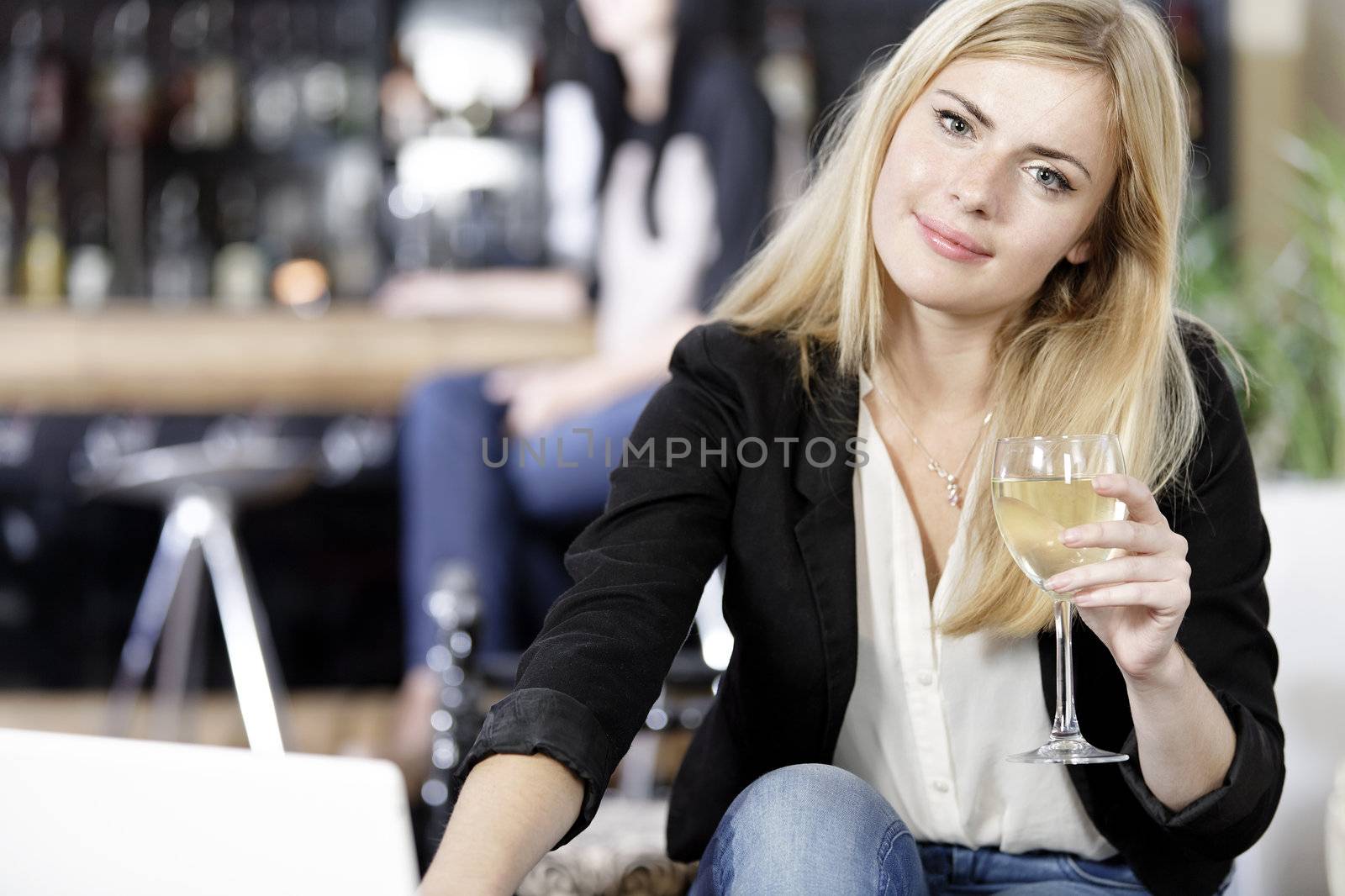 Woman on laptop in wine bar by studiofi