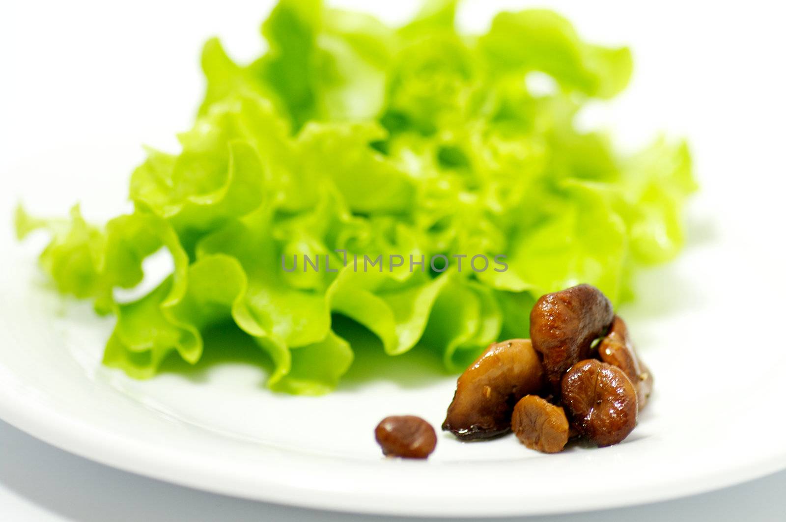 Chanterelles mushrooms with salad leaves isolated on white background