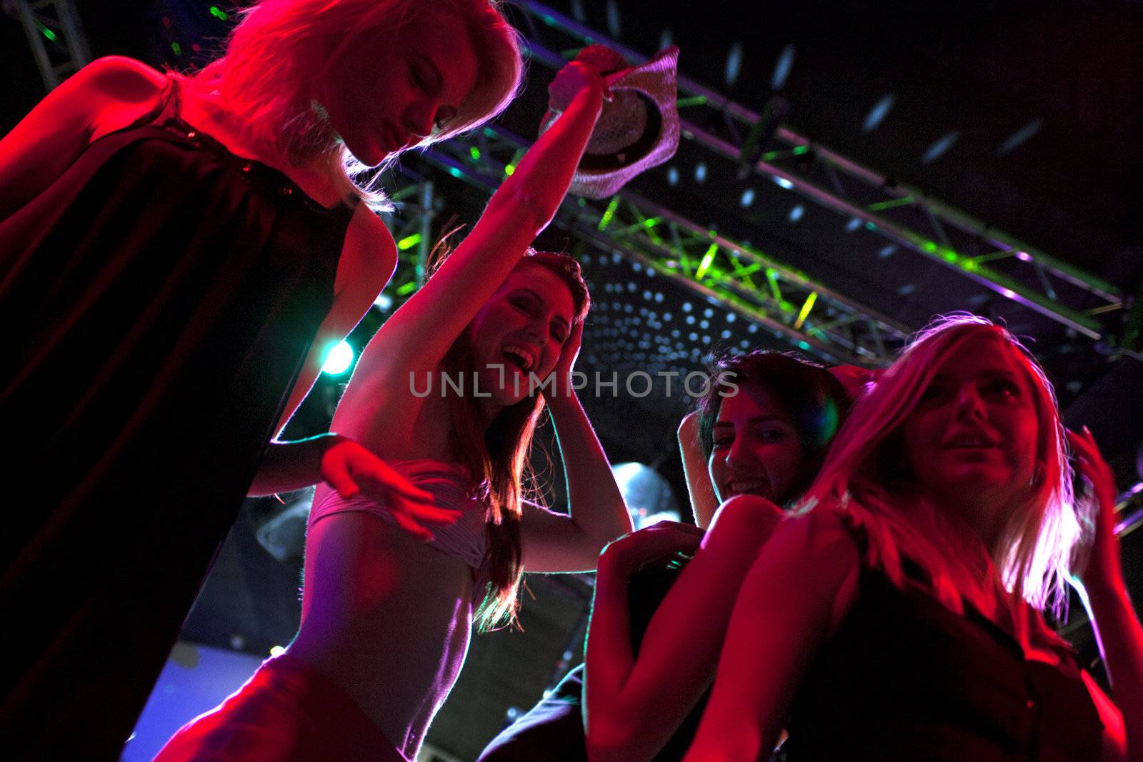 Group of friends dancing at a club by studiofi