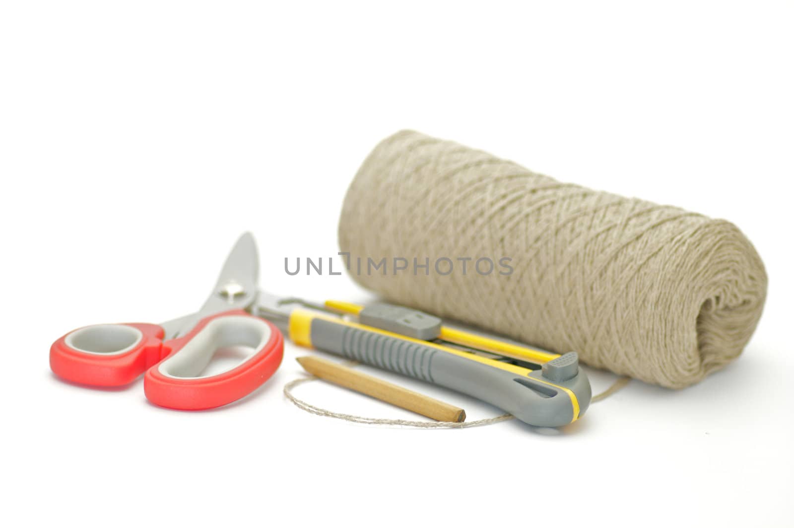 Pack thread, paper knife, pensil and scissors isolated on white background