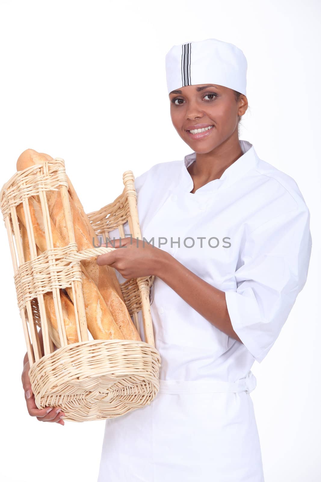 Bakery worker holding basket of bread by phovoir