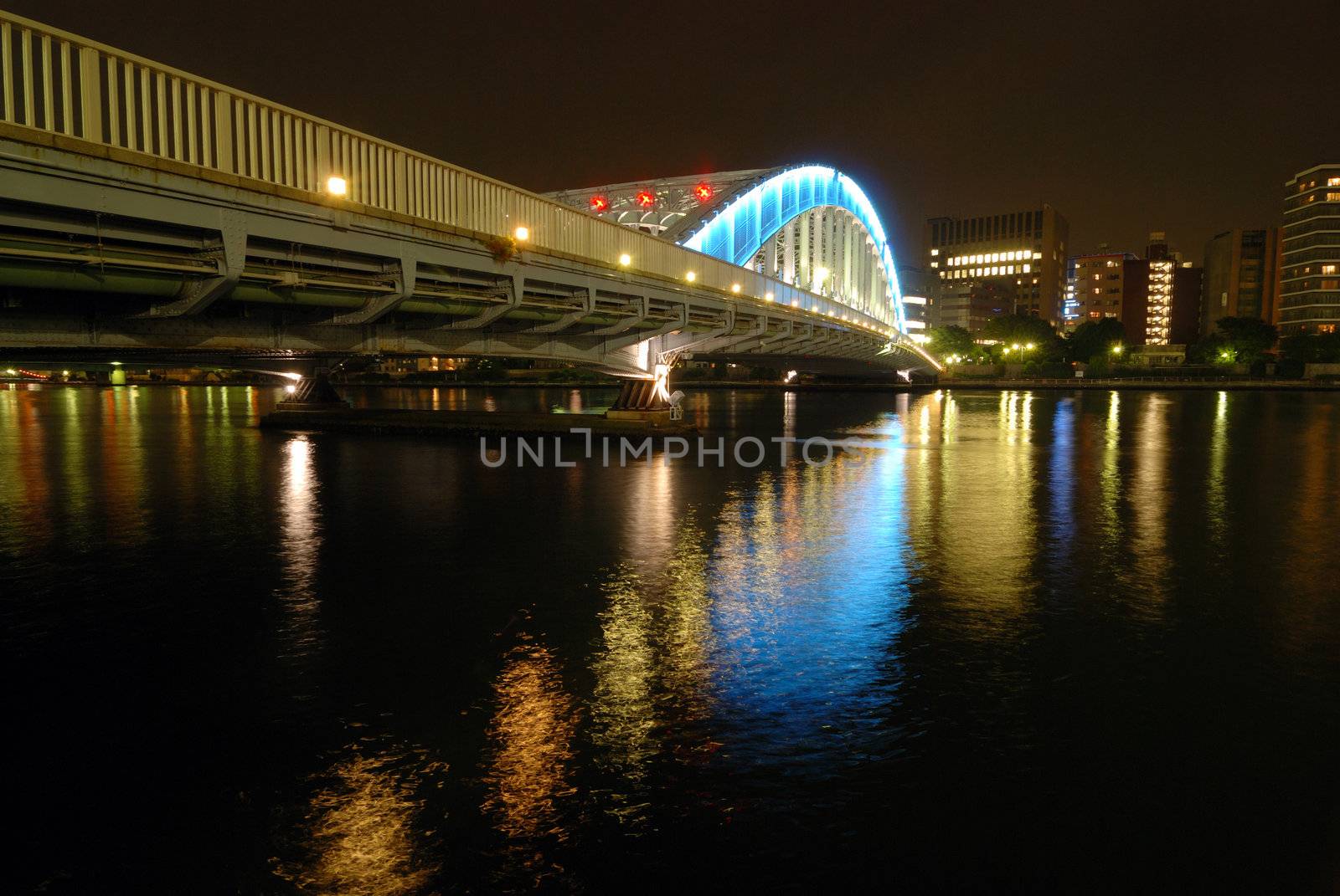 nighttime colorful reflection of Eitai Bridge illumination in waters of Sumida river at central part of Tokyo Metropolis, Japan