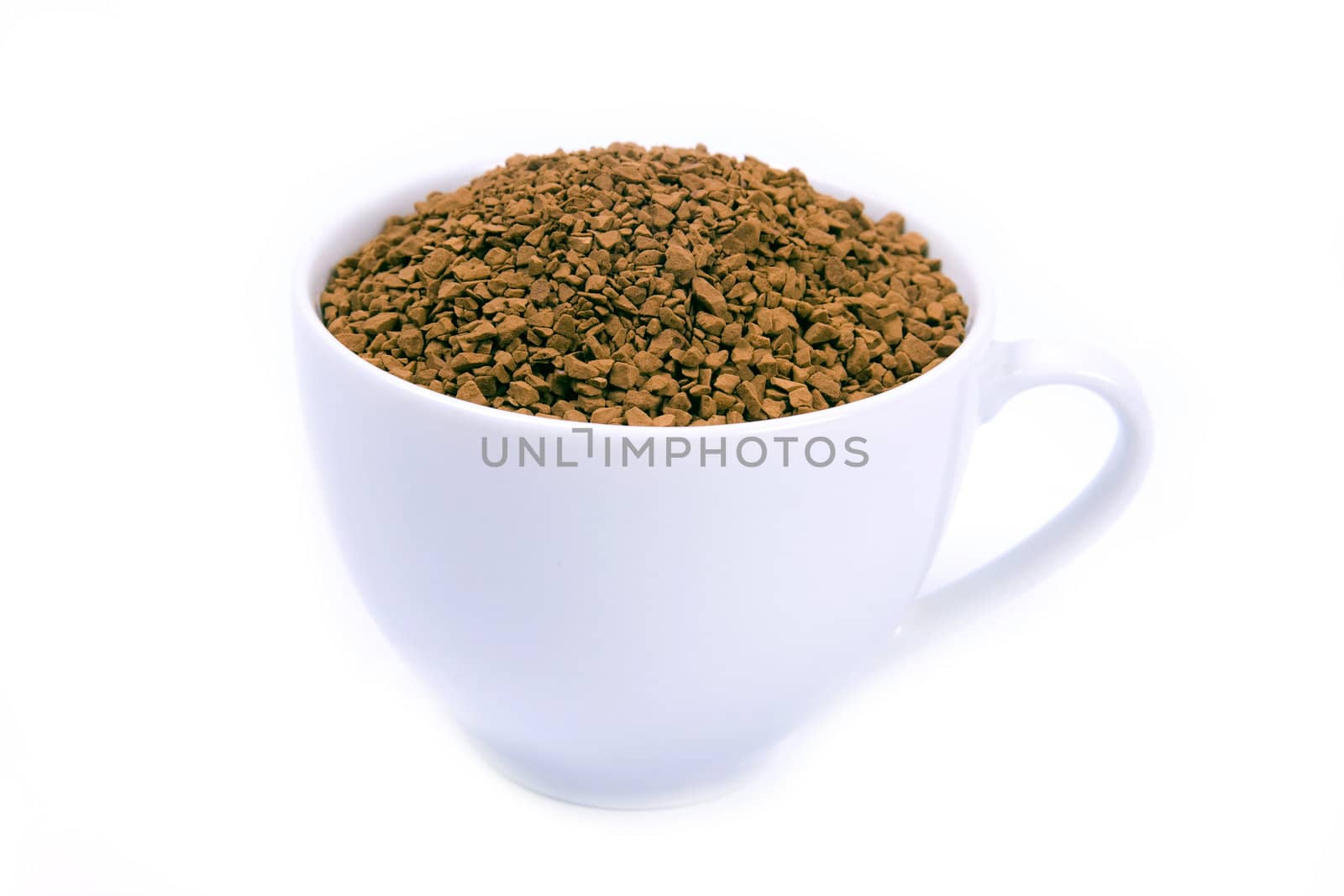 Coffee granules in a white cup isolated.