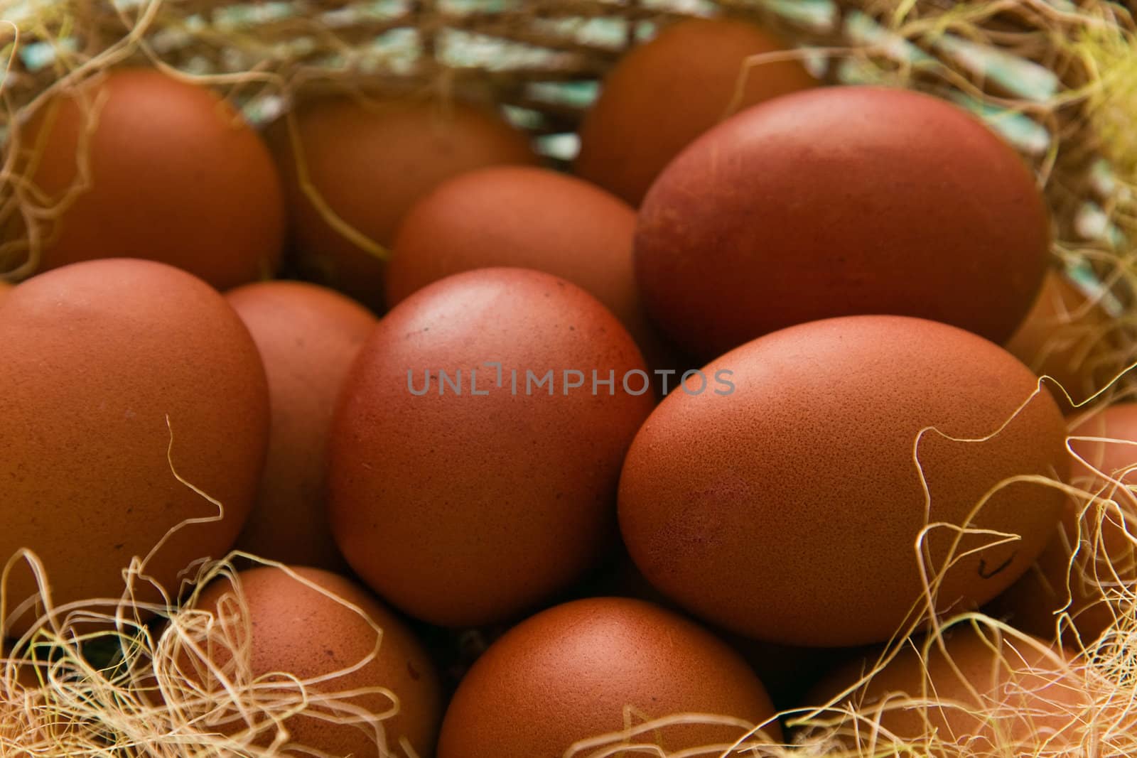 Red easter eggs gathered in a brown wicker basket.