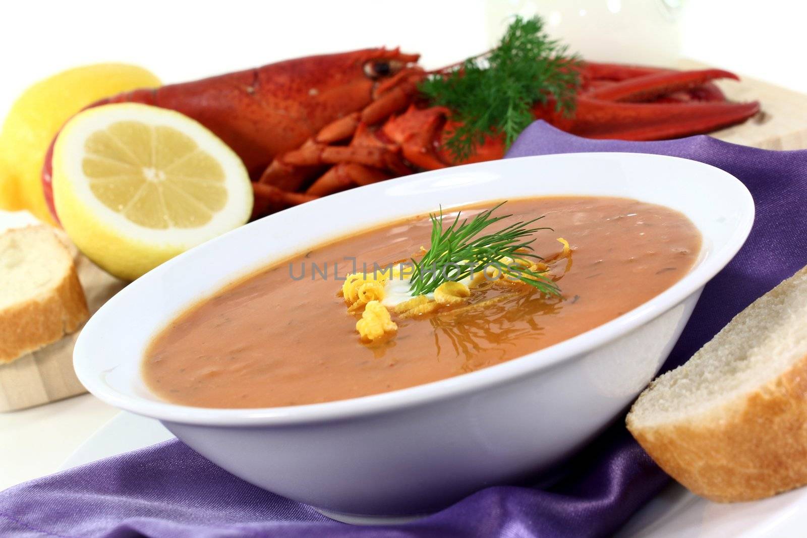 a bowl of lobster soup with dill and lemon