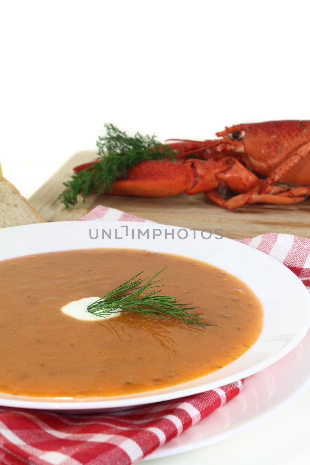 a bowl of lobster soup with dill and lemon